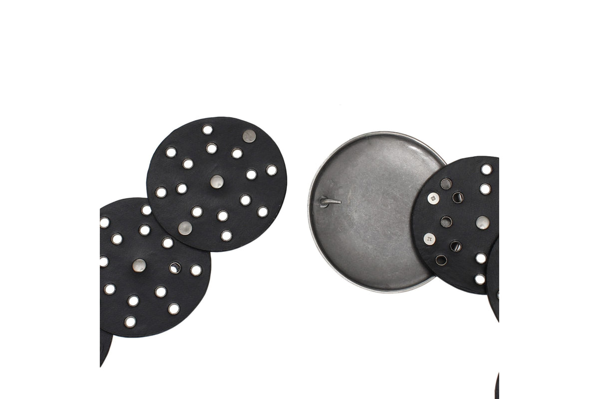 Detail of the hook closure and silver-tone rivets on the black concho belt