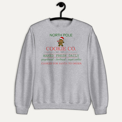 North Pole Cookie Co. Unisex Long Sleeve Sweatshirt in Sport Grey, on hanger