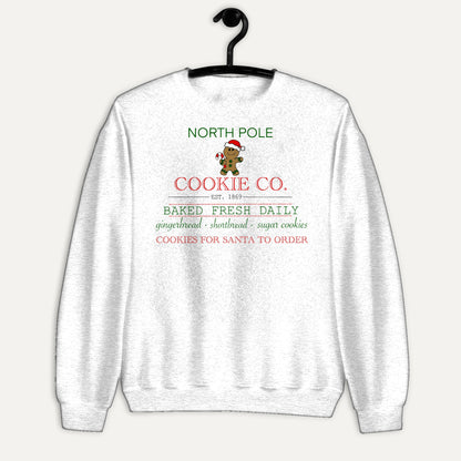 North Pole Cookie Co. Unisex Long Sleeve Sweatshirt in White, on hanger