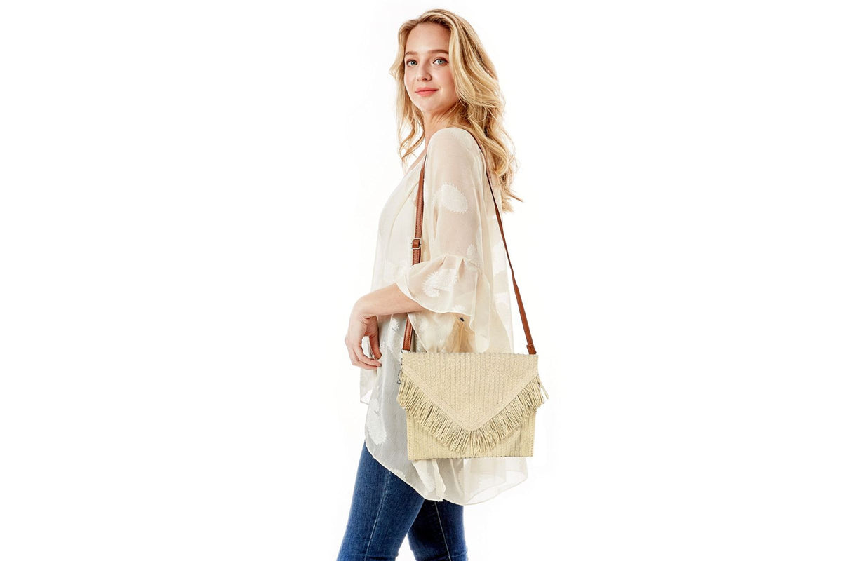 Model carrying the cream straw fringe clutch on her shoulder