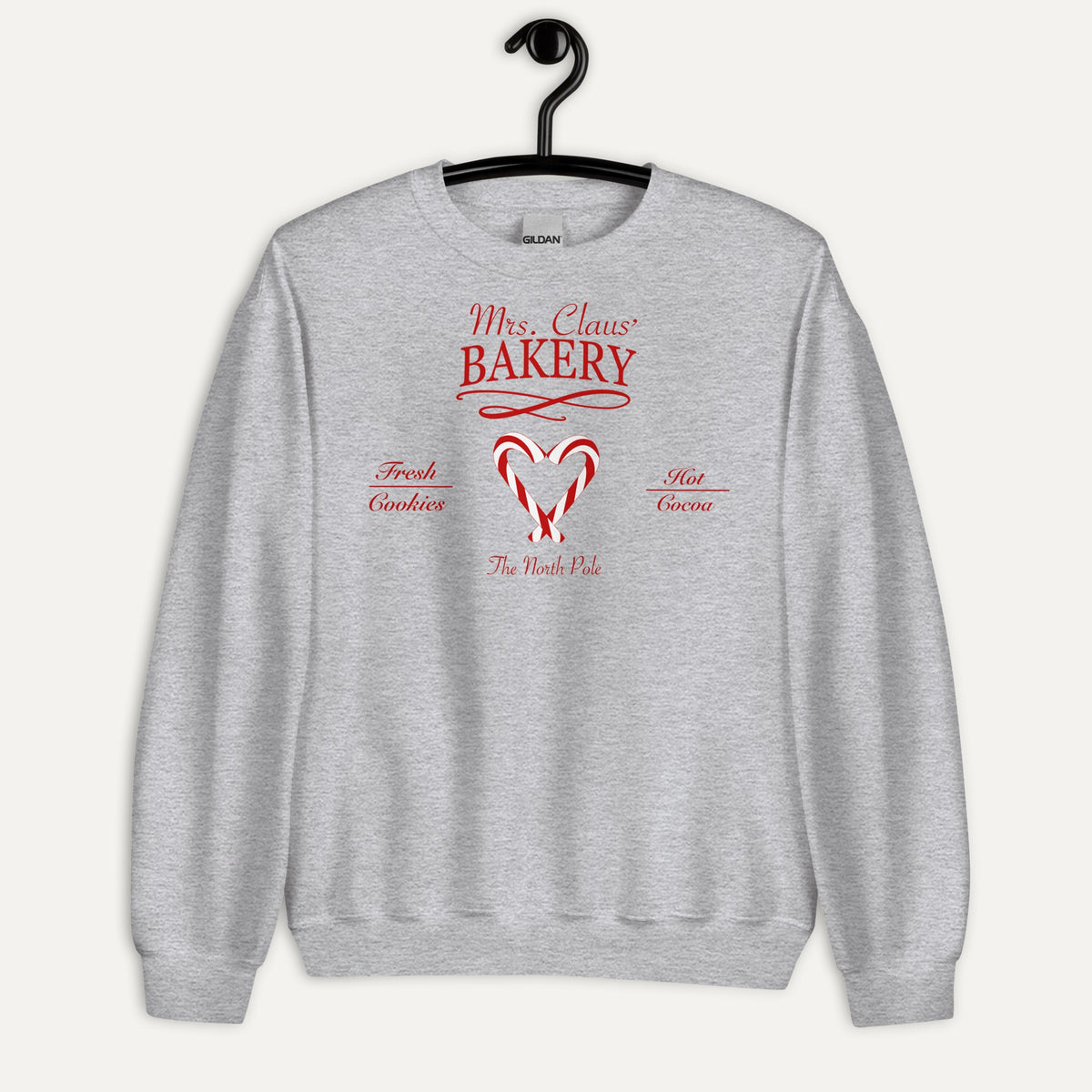 Mrs. Claus' Bakery Unisex Long Sleeve Sweatshirt in Sport Grey, on hanger