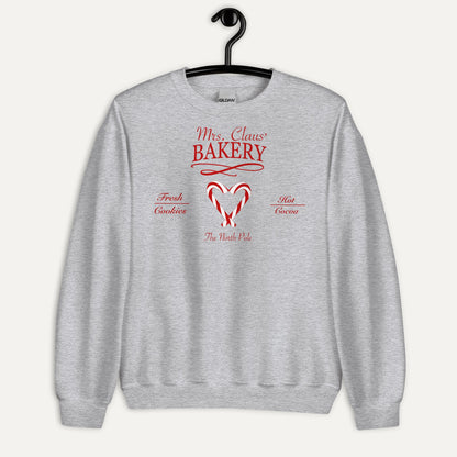 Mrs. Claus' Bakery Unisex Long Sleeve Sweatshirt in Sport Grey, on hanger