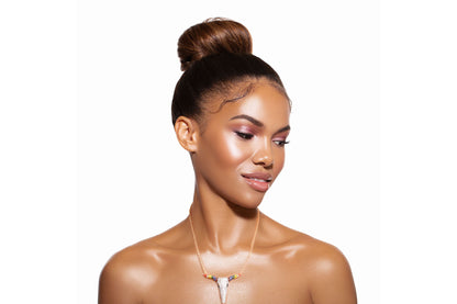 Model wearing a gold-tone necklace with a rainbow rhinestone longhorn pendant