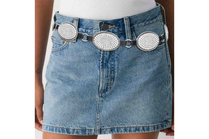 Rhinestone oval concho chain belt worn low on the hips with a denim skirt