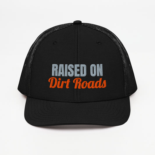 Raised On Dirt Roads embroidered snapback trucker hat in Black with grey and orange embroidery, front view