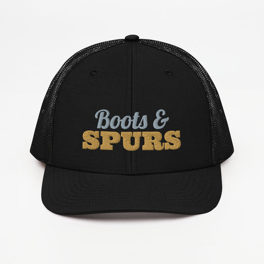 Boots & Spurs embroidered snapback trucker hat in Black with old gold and grey embroidery, front view