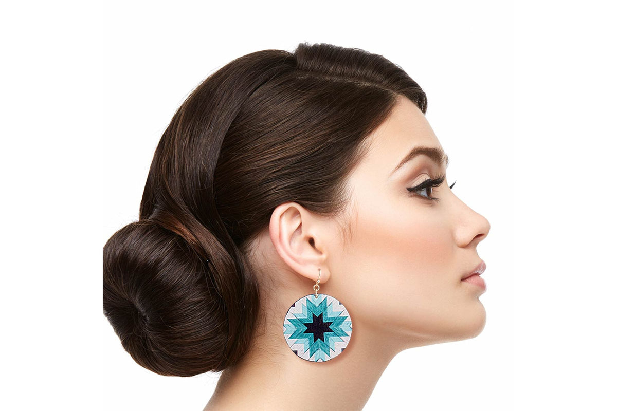 Model in profile wearing round turquoise-colored sunburst drop earrings