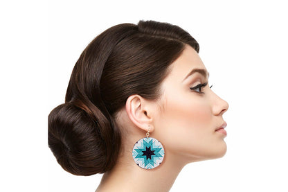Model in profile wearing round turquoise-colored sunburst drop earrings